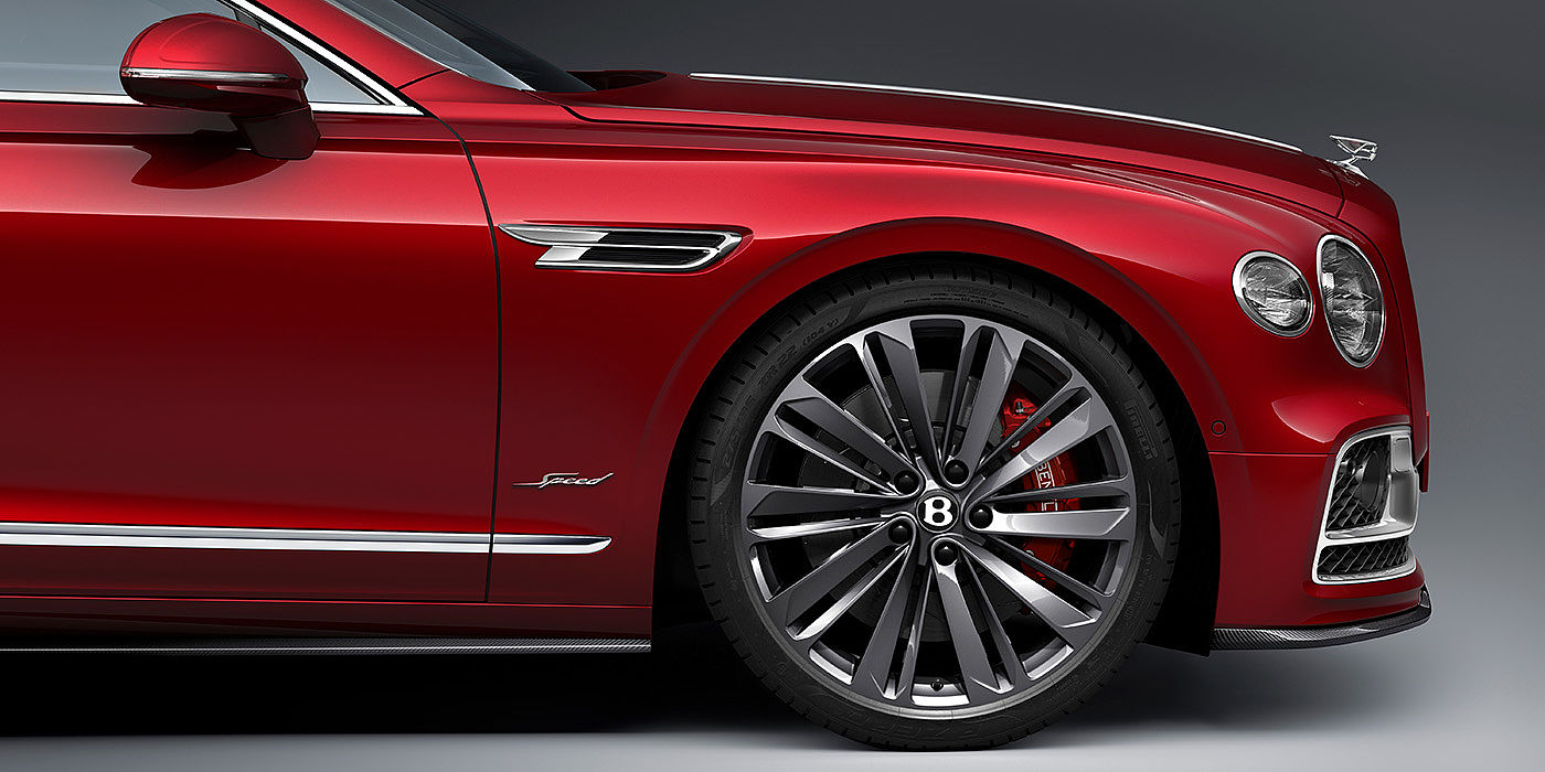 Bentley Newcastle Bentley Flying Spur Speed sedan front wheel in close up with Dragon Red II paint